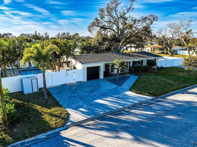 ranch-style home with a garage and a front lawn