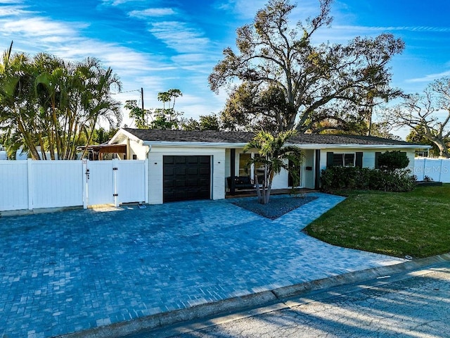 ranch-style house featuring a garage and a front yard