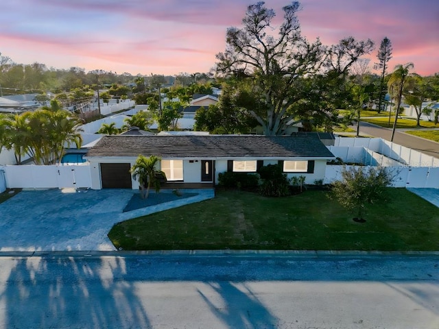 view of front of house with a garage and a yard