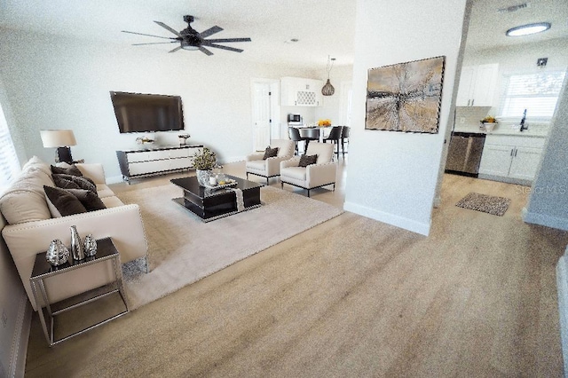 carpeted living room with sink and ceiling fan