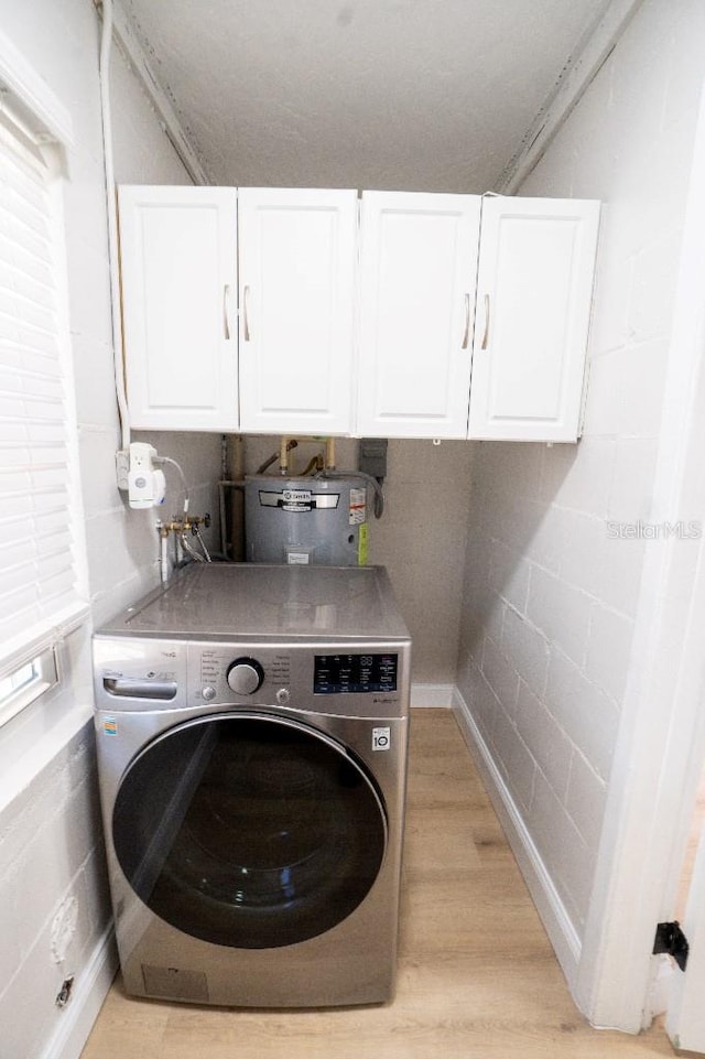 laundry area with washer / clothes dryer, electric water heater, cabinets, and light wood-type flooring