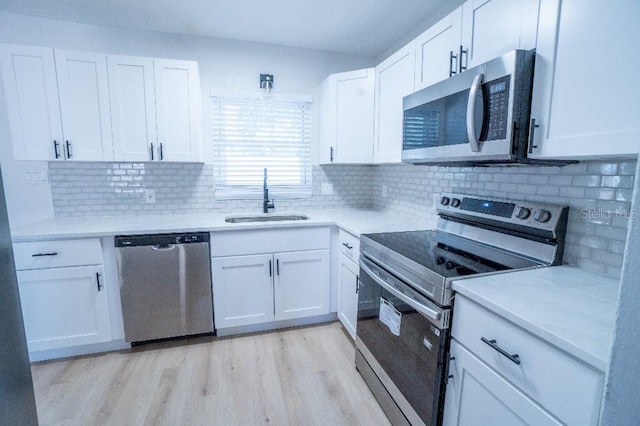 kitchen featuring white cabinetry, sink, and appliances with stainless steel finishes