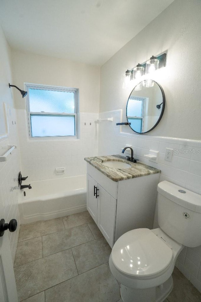 full bathroom with tile walls, tile patterned flooring, vanity, toilet, and tub / shower combination