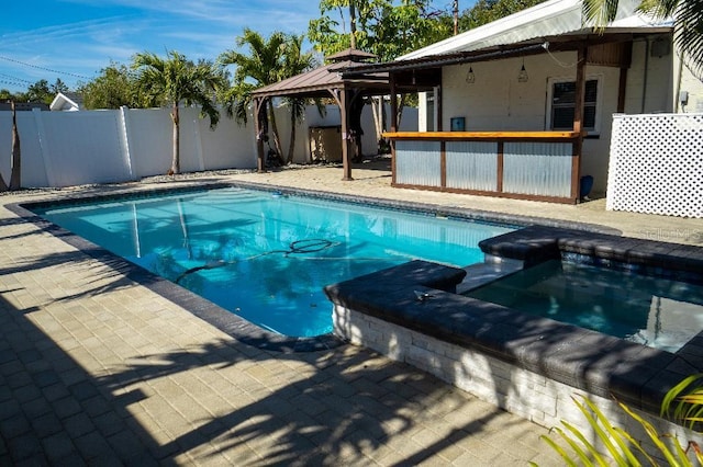 view of pool with a gazebo and an in ground hot tub