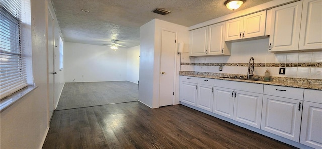 kitchen featuring sink, stone countertops, dark hardwood / wood-style floors, ceiling fan, and white cabinets