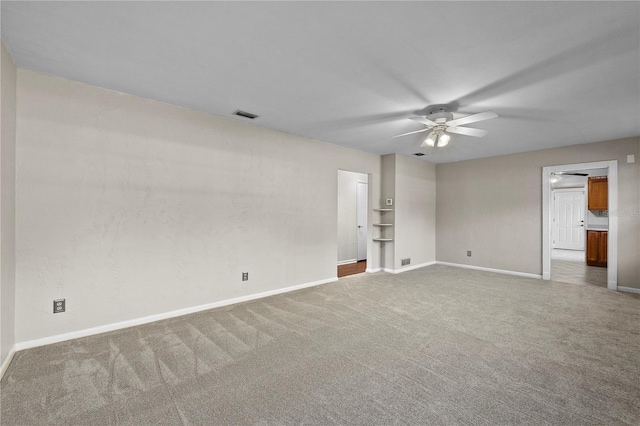 carpeted spare room featuring ceiling fan