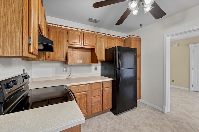 kitchen featuring light tile patterned floors, ceiling fan, black refrigerator, range with electric cooktop, and exhaust hood