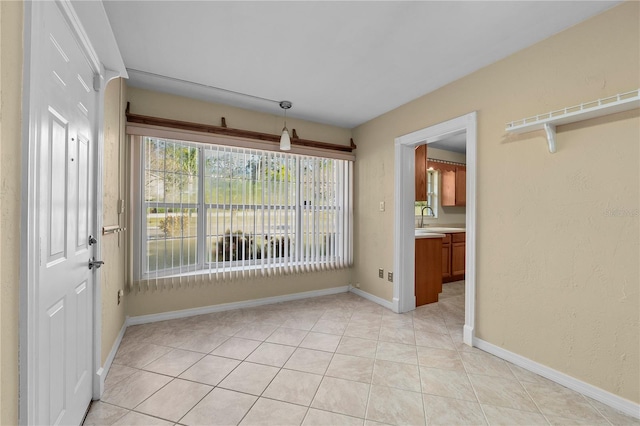 unfurnished dining area with light tile patterned flooring and sink