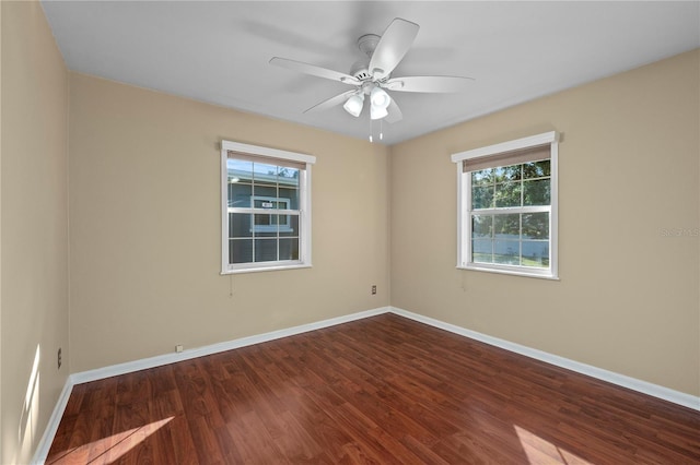 empty room with ceiling fan and dark hardwood / wood-style flooring