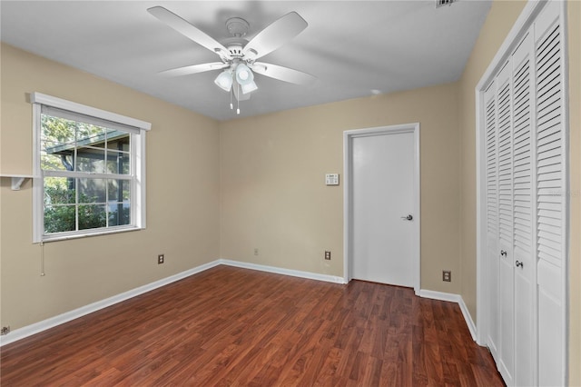 unfurnished bedroom featuring dark wood-type flooring, ceiling fan, and a closet