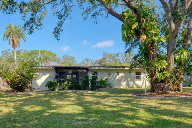 view of front of home featuring a front lawn and a sunroom