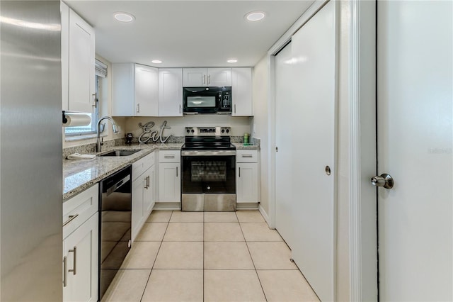 kitchen featuring sink, white cabinetry, black appliances, light stone countertops, and light tile patterned flooring