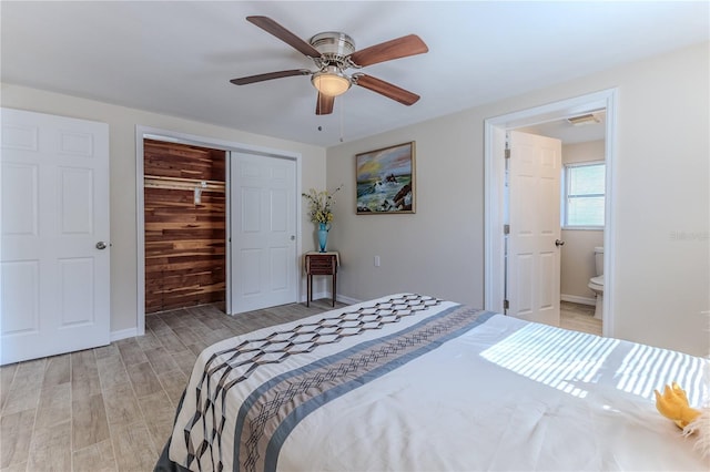 bedroom featuring ceiling fan, ensuite bathroom, a closet, and light hardwood / wood-style flooring