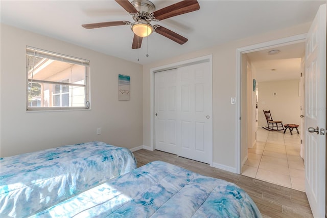 bedroom featuring ceiling fan, light hardwood / wood-style floors, and a closet