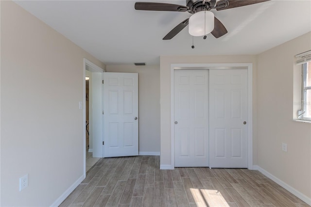 unfurnished bedroom with ceiling fan and a closet