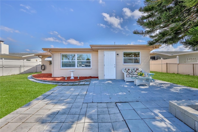 back of property featuring a patio area and a lawn