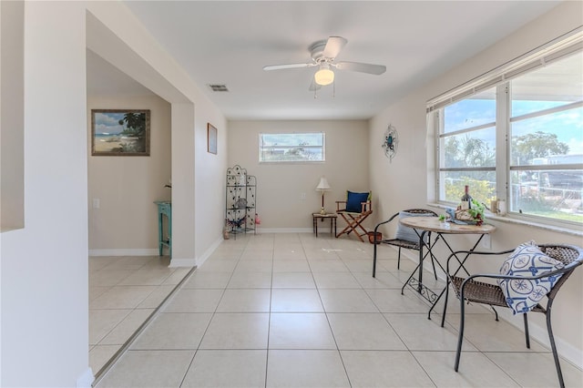 living area featuring light tile patterned floors and ceiling fan