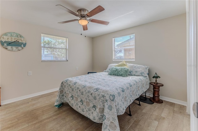 bedroom with multiple windows, ceiling fan, and light hardwood / wood-style floors