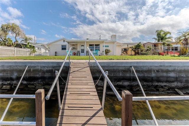 dock area with a yard and a water view