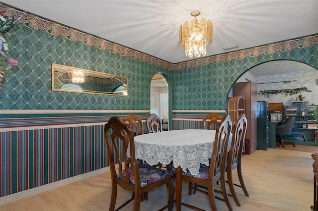 dining room featuring wood-type flooring and a notable chandelier