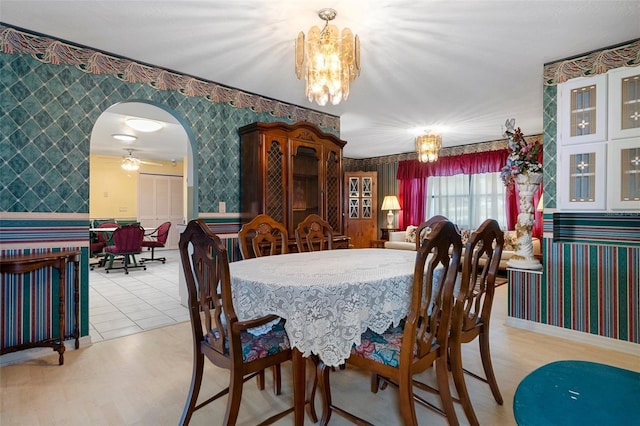 dining room with ceiling fan with notable chandelier and light wood-type flooring