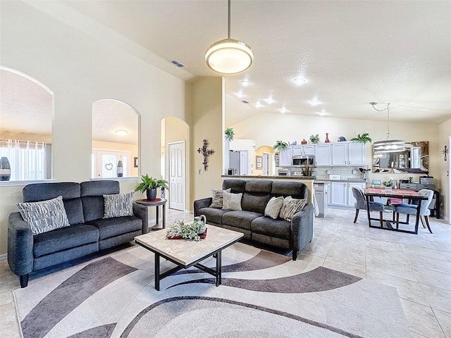 tiled living room with high vaulted ceiling