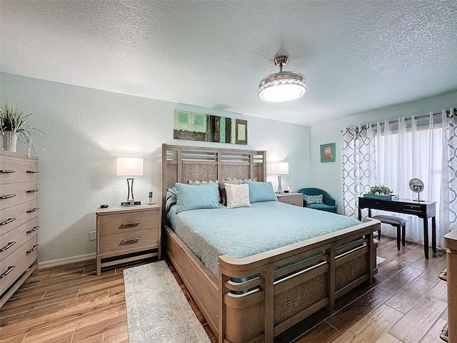 bedroom with hardwood / wood-style floors and a textured ceiling