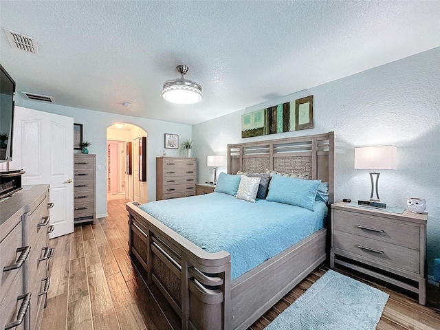 bedroom with dark wood-type flooring and a textured ceiling