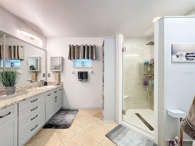 bathroom featuring vanity, a textured ceiling, and walk in shower