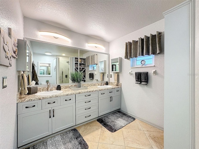 bathroom featuring vanity, a shower with shower door, and a textured ceiling