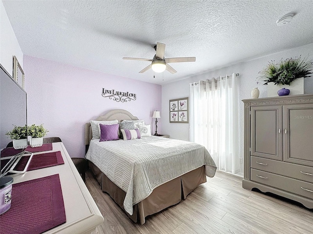 bedroom featuring ceiling fan, light hardwood / wood-style floors, and a textured ceiling