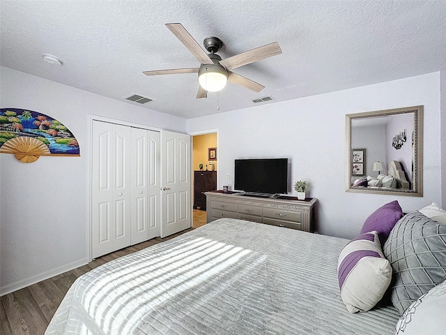 bedroom featuring ceiling fan, a closet, hardwood / wood-style floors, and a textured ceiling