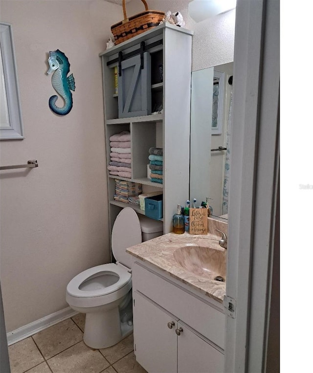 bathroom featuring tile patterned floors, vanity, and toilet