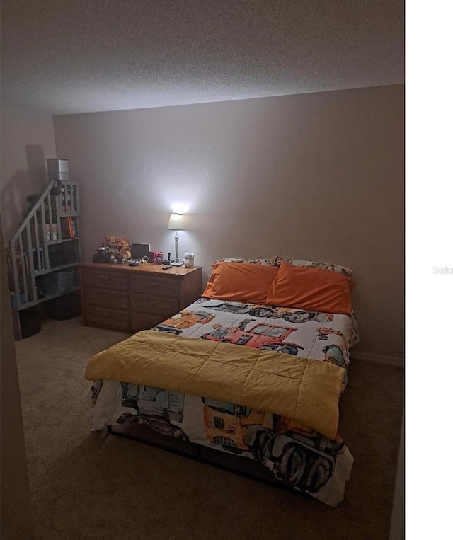 bedroom with carpet floors and a textured ceiling