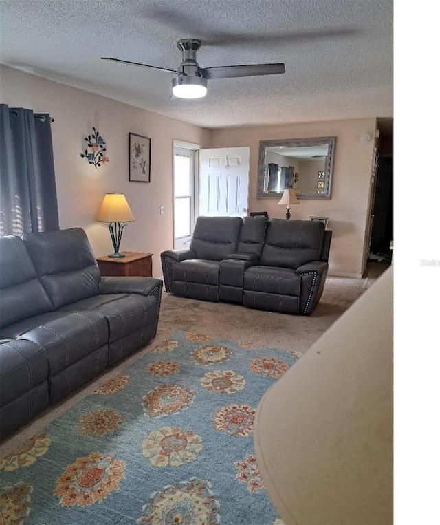 carpeted living room with ceiling fan and a textured ceiling