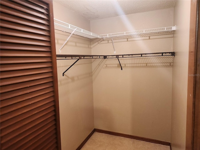 walk in closet featuring light tile patterned flooring