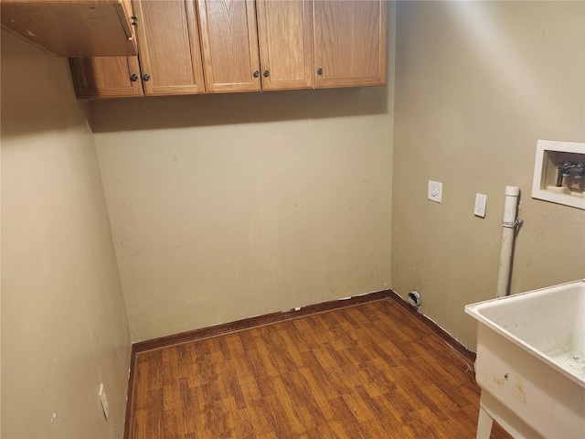 washroom with cabinets, hookup for a washing machine, dark wood-type flooring, and sink