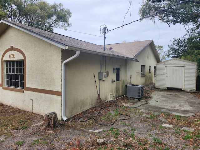 view of side of home featuring a storage shed and central AC unit