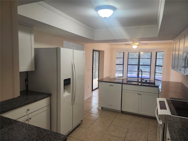 kitchen featuring white appliances, a sink, a raised ceiling, light tile patterned floors, and ceiling fan