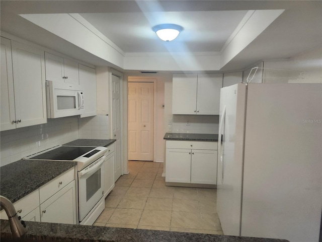 kitchen with white appliances, a tray ceiling, light tile patterned floors, backsplash, and dark countertops