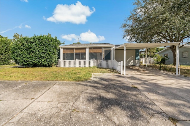 view of front facade featuring a sunroom, concrete driveway, and a carport
