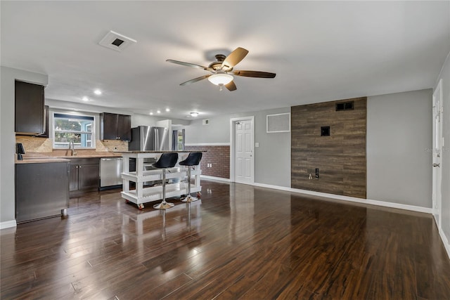 living area featuring a ceiling fan, baseboards, dark wood finished floors, and recessed lighting