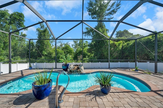 view of swimming pool with a patio area, pool water feature, and glass enclosure