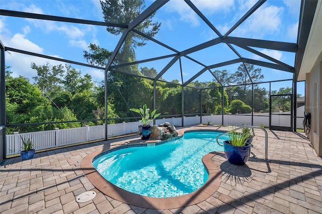 view of pool featuring a patio area, pool water feature, and glass enclosure