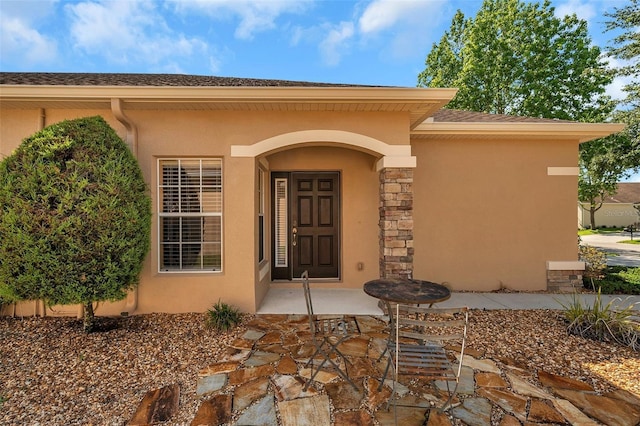 view of exterior entry with a patio area