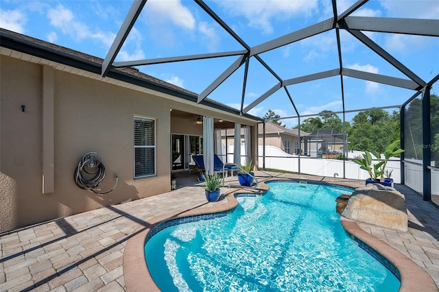 view of pool featuring a lanai, ceiling fan, and a patio area