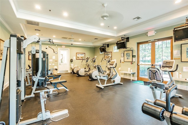 workout area with a raised ceiling, ornamental molding, ceiling fan, and french doors