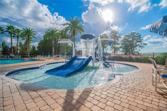 view of swimming pool with a playground and pool water feature