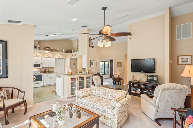 carpeted living room with high vaulted ceiling and ceiling fan