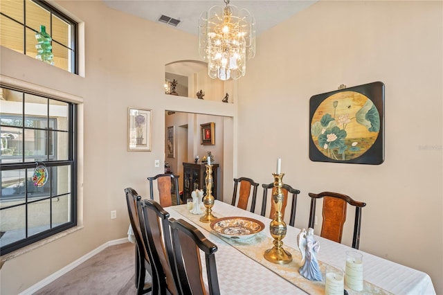 carpeted dining area with a chandelier and built in features